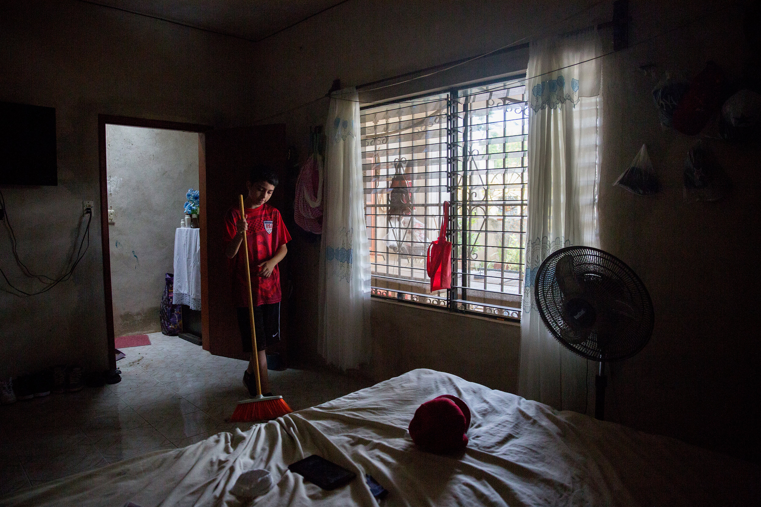  Luis Lara, 12, sweeps up after being told to get off of his phone and help around his aunt and uncle's house in Hoctún, Yucatán. Luis came from Dallas to live with his family and learn Spanish for the summer.&nbsp;(Courtney Pedroza/Dallas Morning Ne