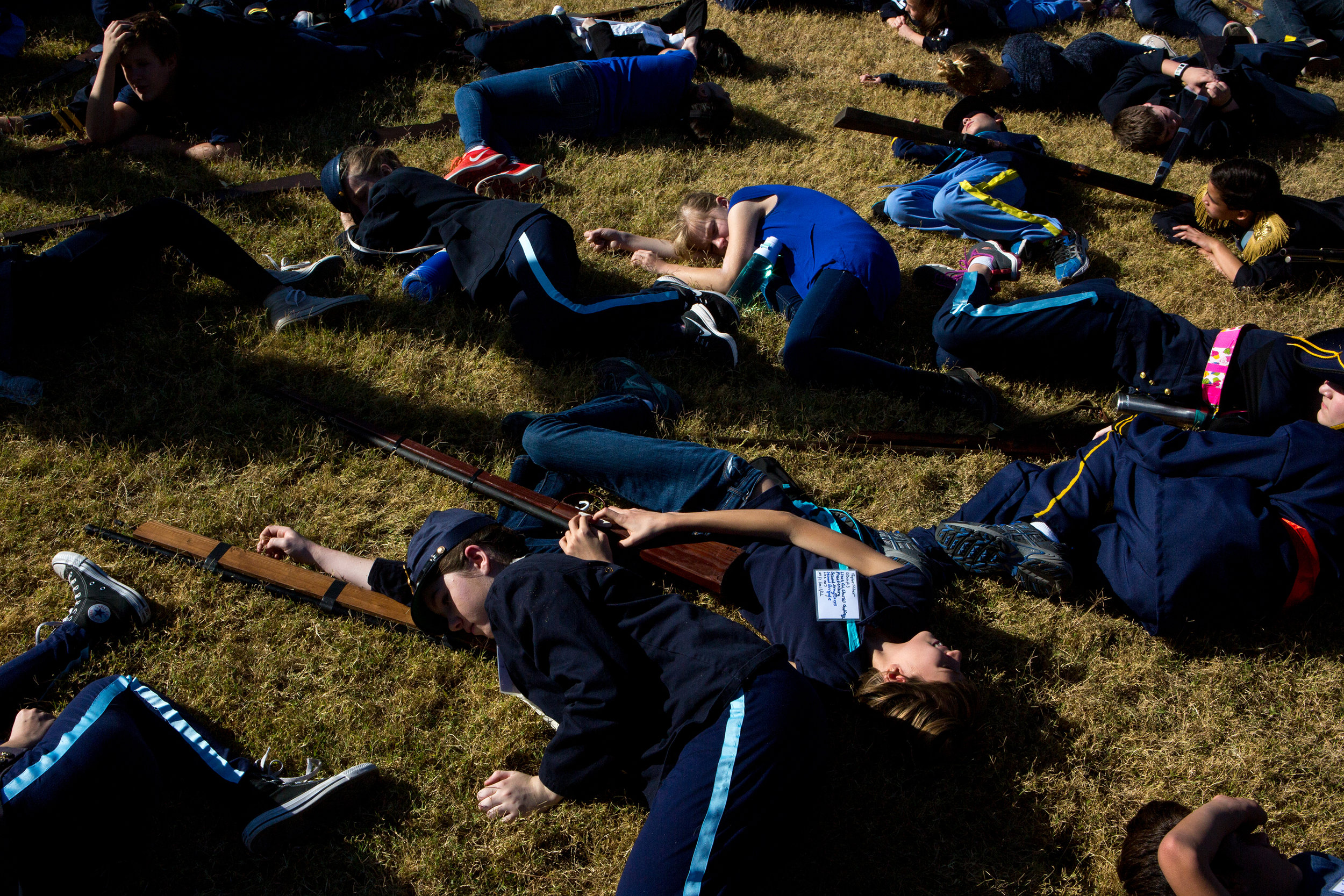  Students at Desert Shadows Middle School pretend to be dead in the grass at Sereno Park during the annual 7th-grade reenactment of the Battle of Gettysburg on Nov. 17, 2016. Lying next to them are the homemade wooden guns required for their class gr