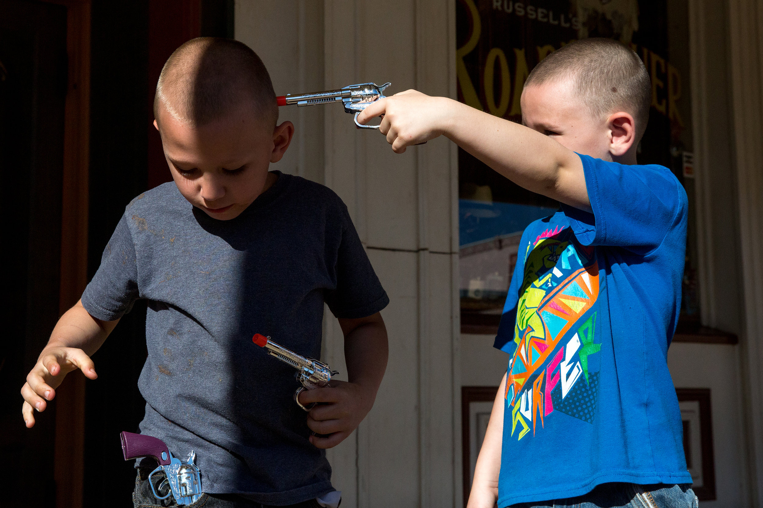  Blake Wooldrige (right) points a toy gun at his younger brother, Nicholas Wooldrige, after his mother told him not to, on Allen Street in Tombstone, Ariz., on April 9, 2016.  