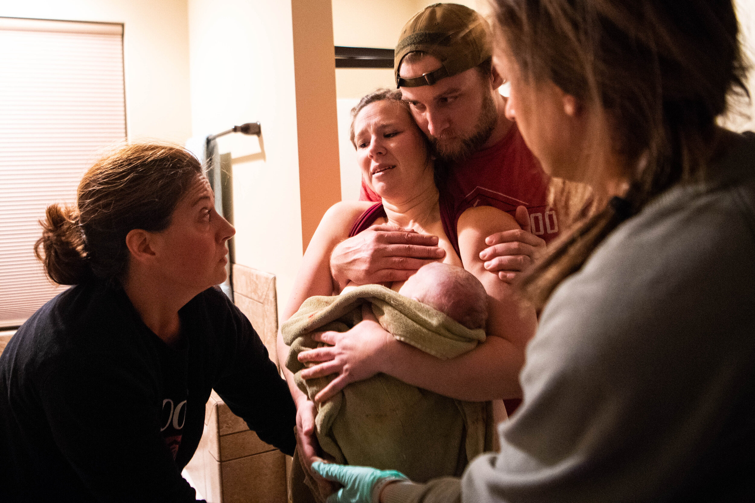  Midwife Gaylea McDougal of Roots Childbirth discusses cutting the cord as Eric Wehmeyer holds his wife, Beth, and she holds their son Henry Hudson after giving birth at their home. 