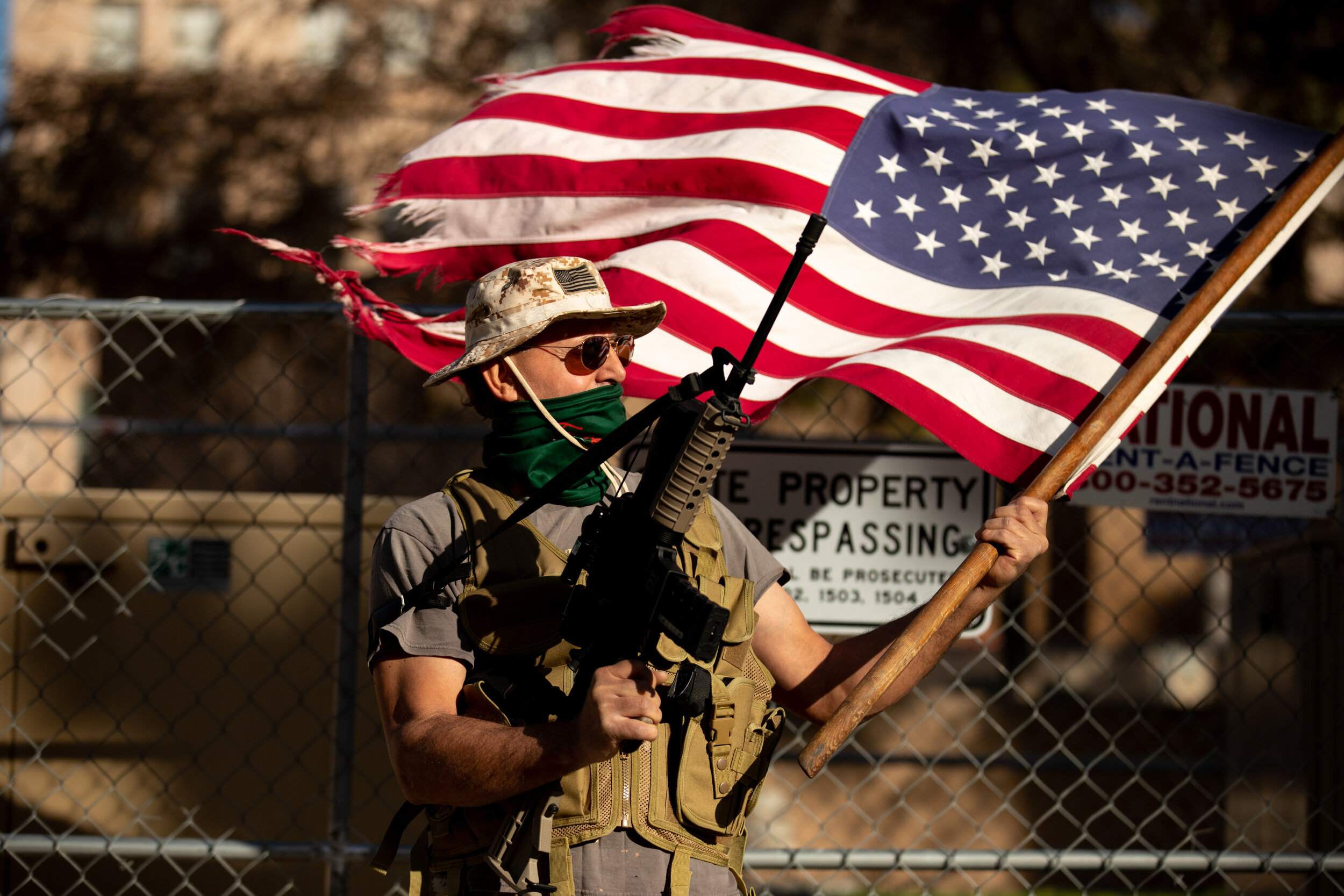  A supporter of President Trump holds a flag and gun outside the Arizona State Capitol on January 20, 2021 in Phoenix, Arizona. (Photo by Courtney Pedroza for the Washington Post) 