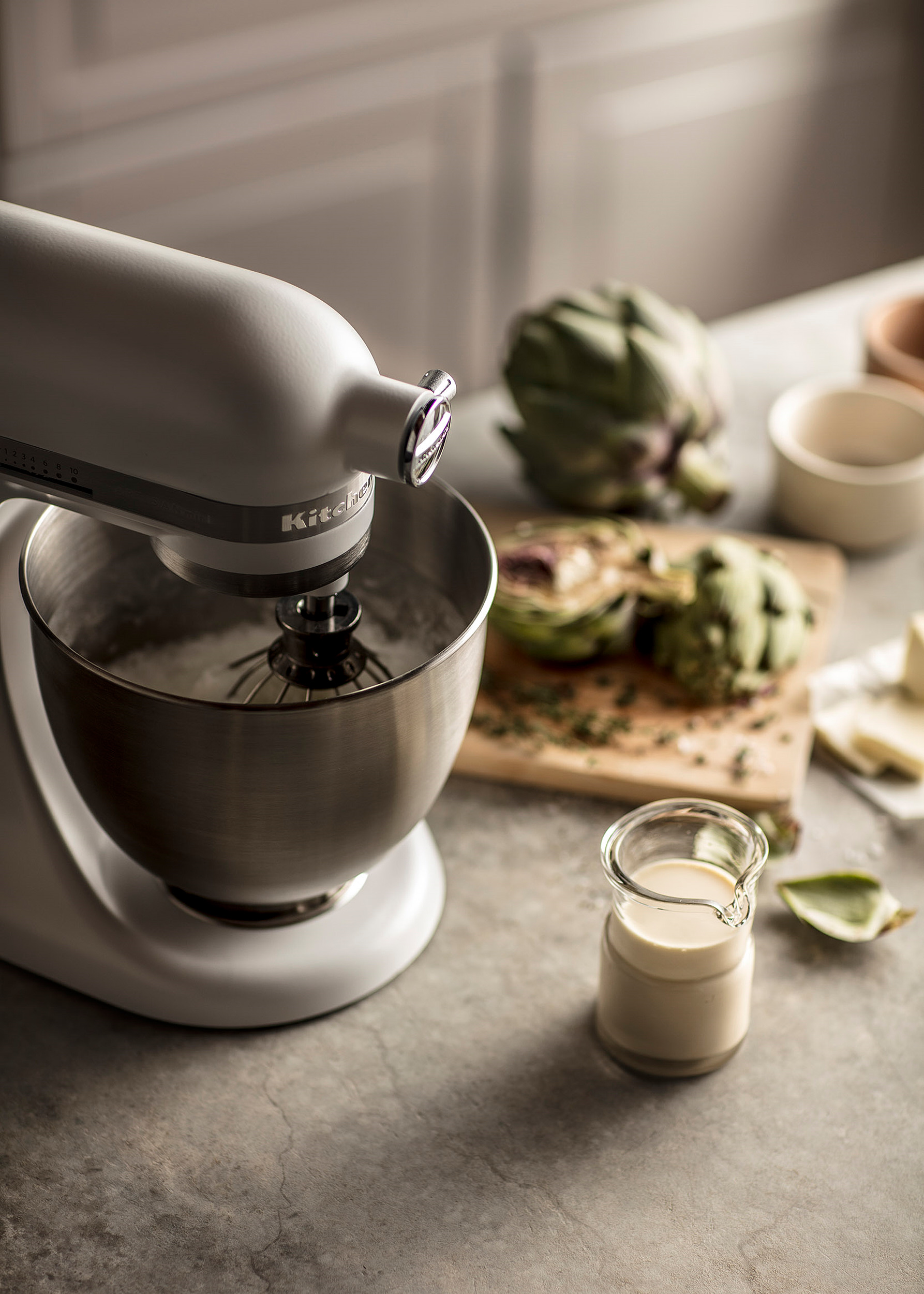 White KitchenAid Stand Mixer preparing an artichoke soufflé.