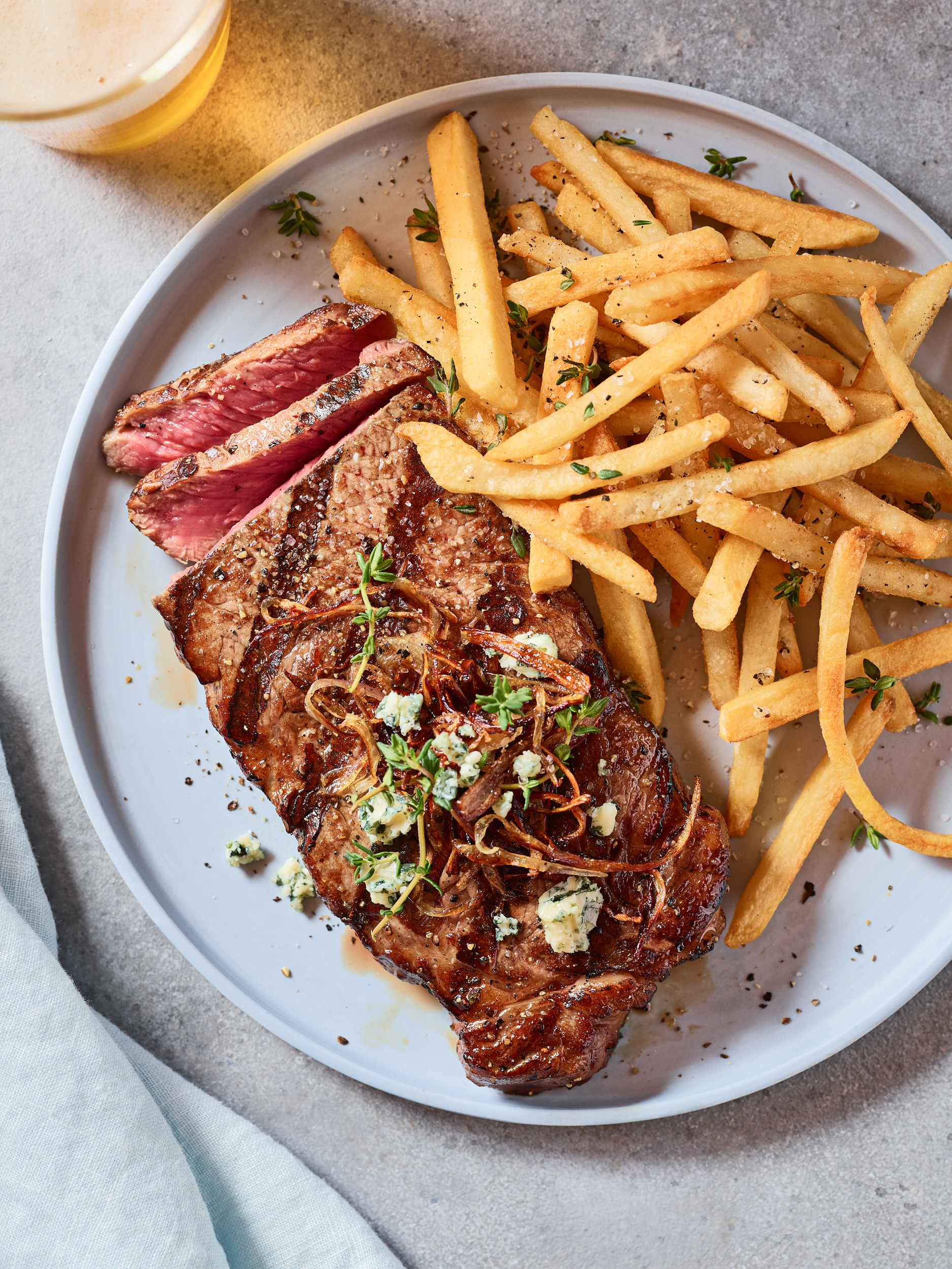 Steak Frites with crispy onion and blue cheese with a light beer.