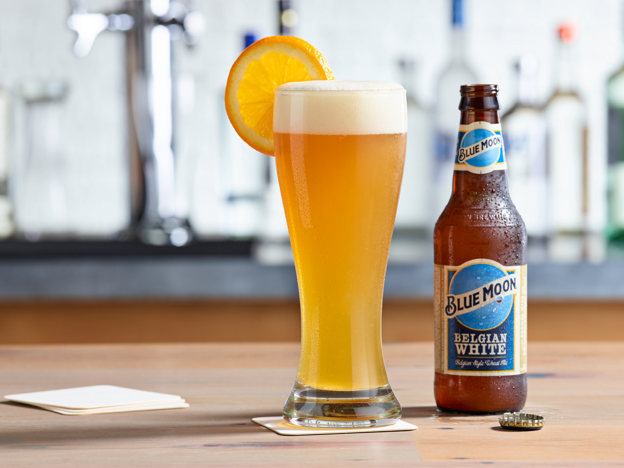 Blue moon beer in pint glass with orange wheel.