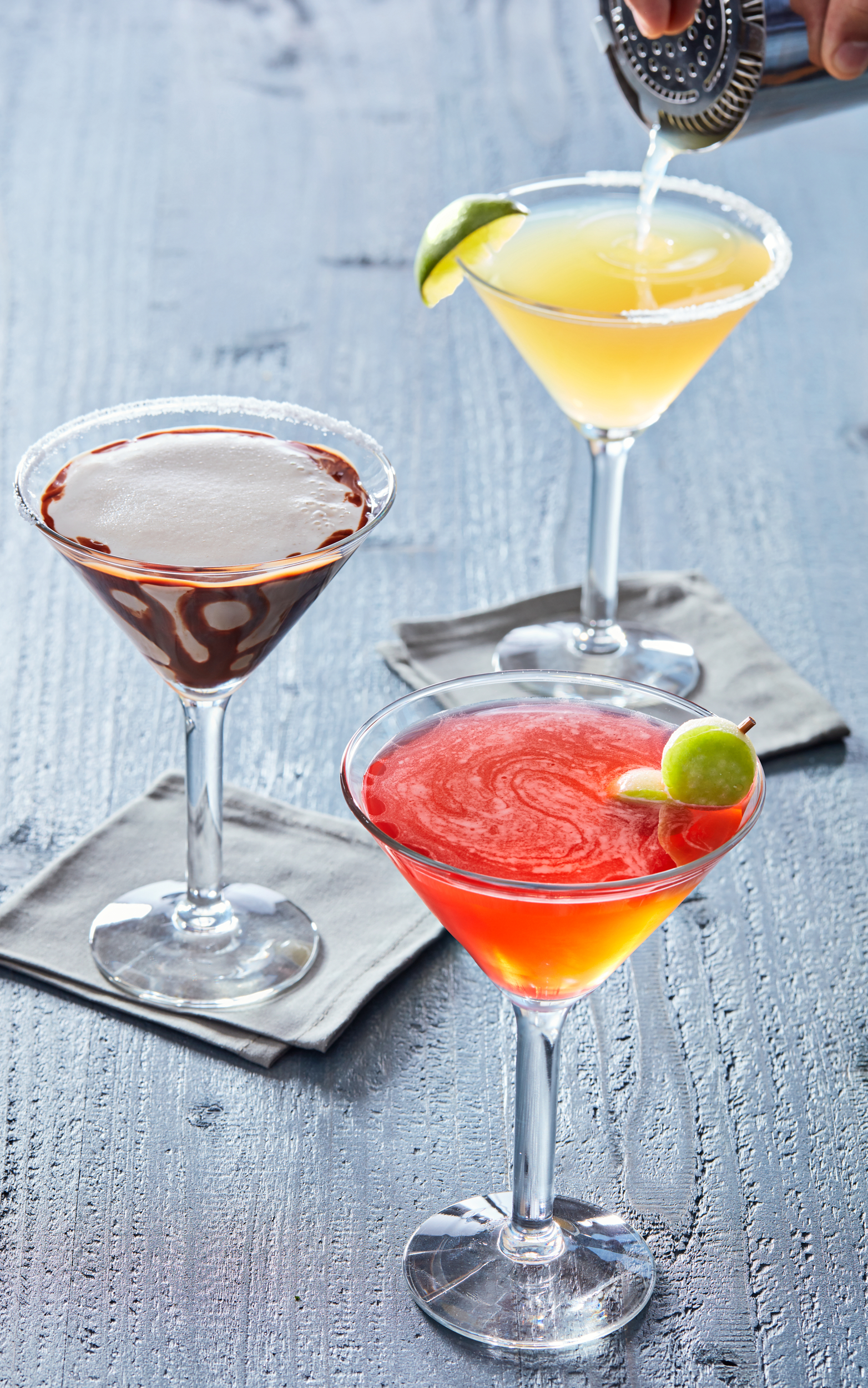 Three shaken cocktails; apple martini, mudslide and fresh squeezed margarita.