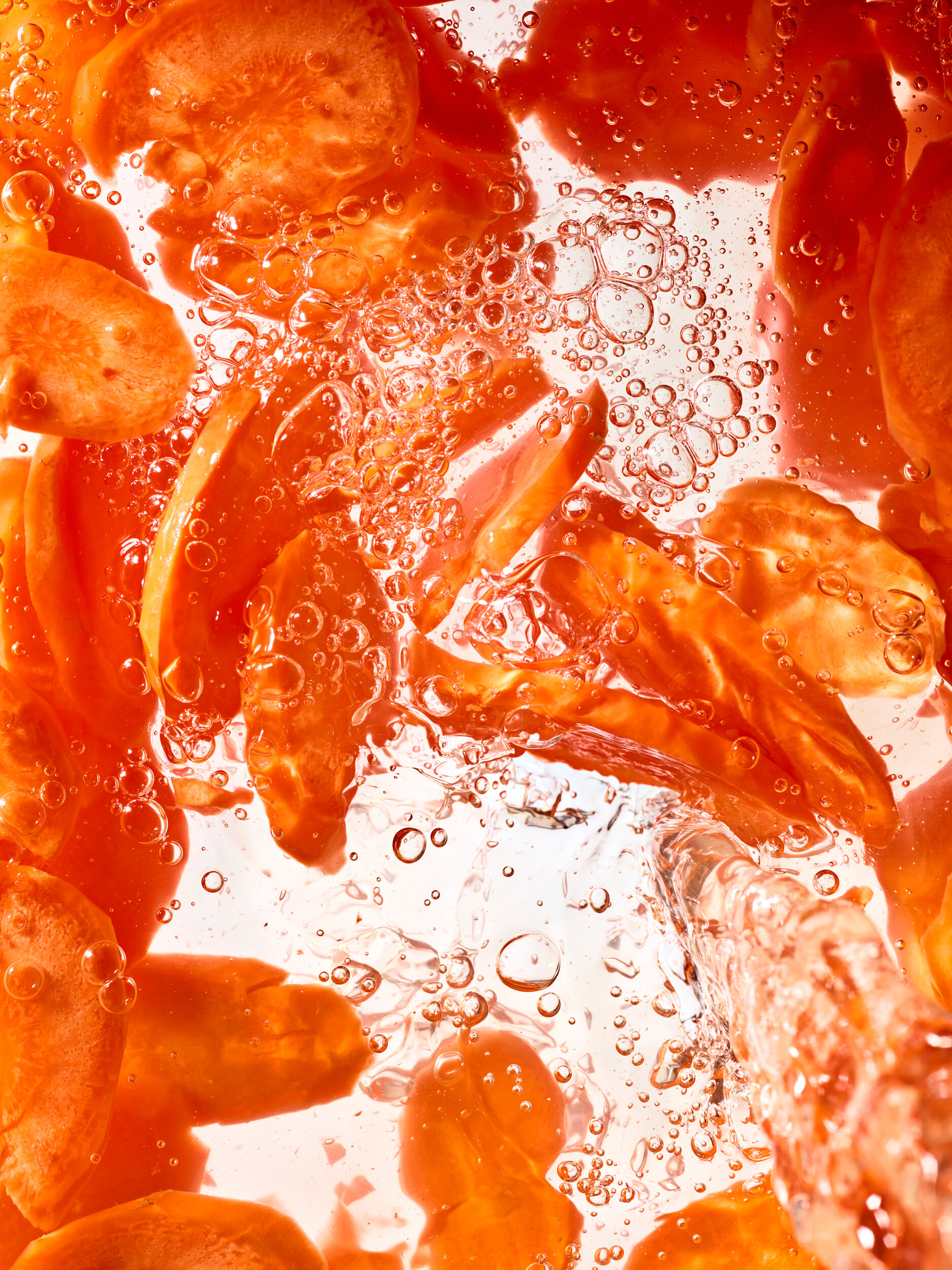 A high speed photograph of pickled carrots frozen in time being poured out of a jar.