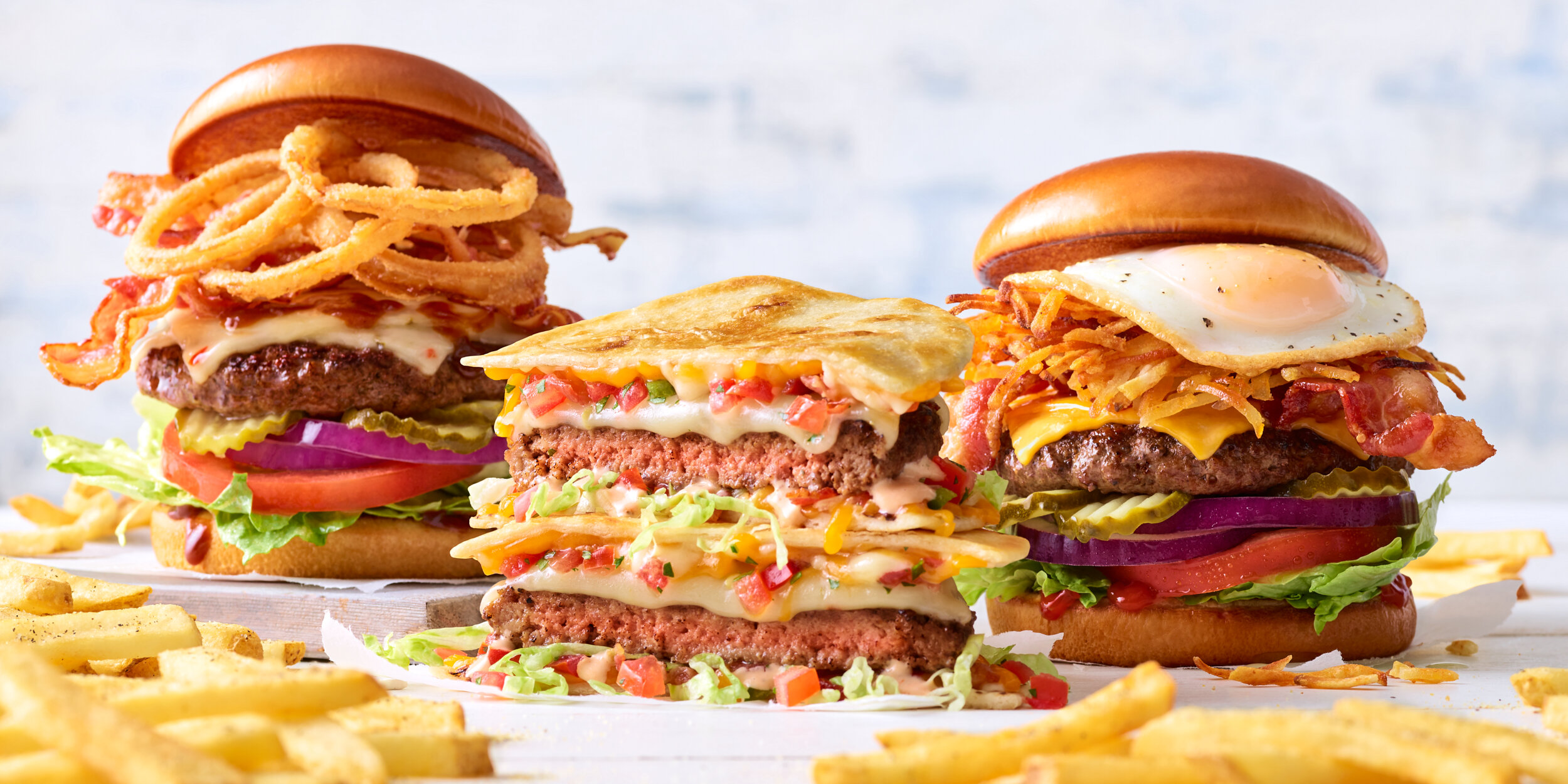 Applebee’s fast food burger trio; BBQ bacon burger, quesadilla burger and breakfast burger.