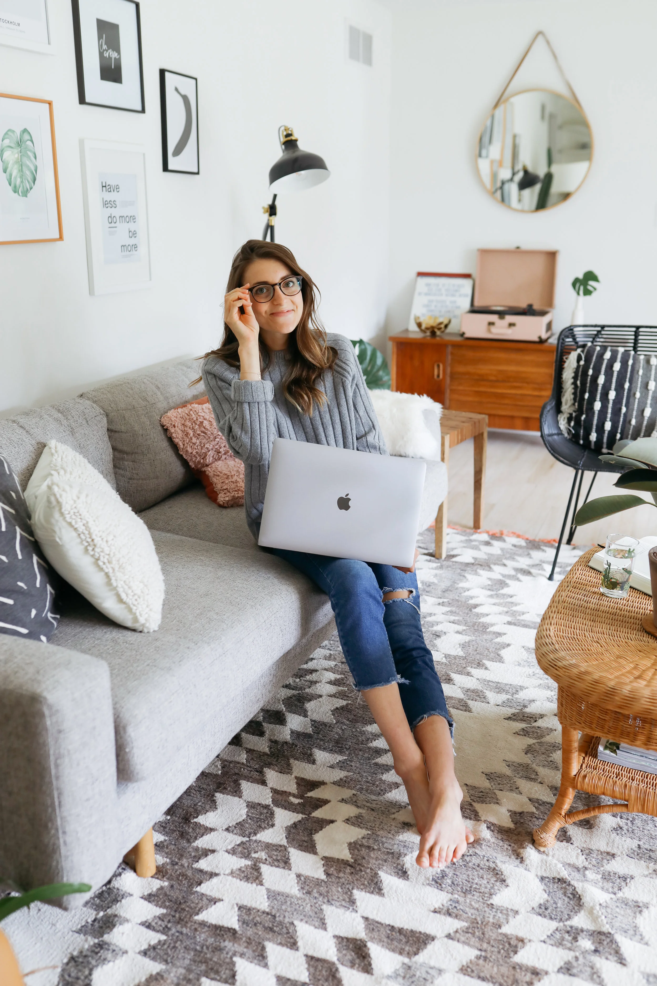 Wearing glasses and posing in the home office, laptop in hand, Emily works on writing “done is better than perfect”