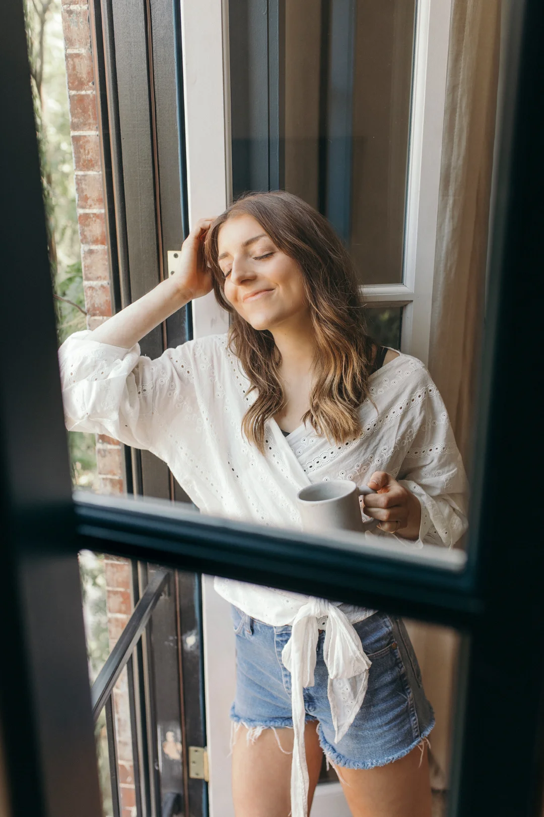 Relaxing next to a large window taking in the glow of the sun, beautiful nature, and fresh air, coffee cup in hand of course!