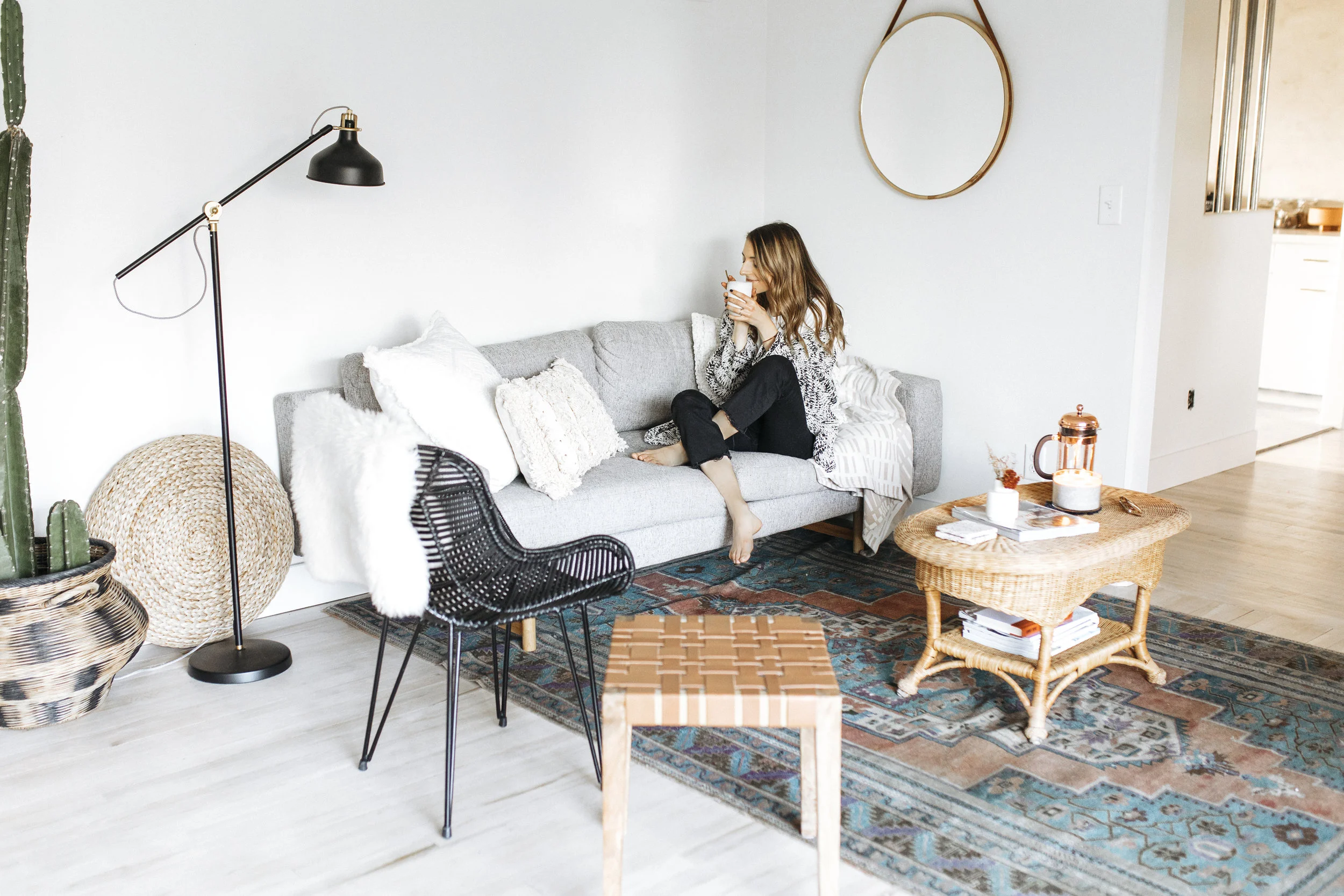 Blogger cuddles with her woven blankets, sipping tea, after hygge -ing up her home for the fall season. Sweaters and candles are in!