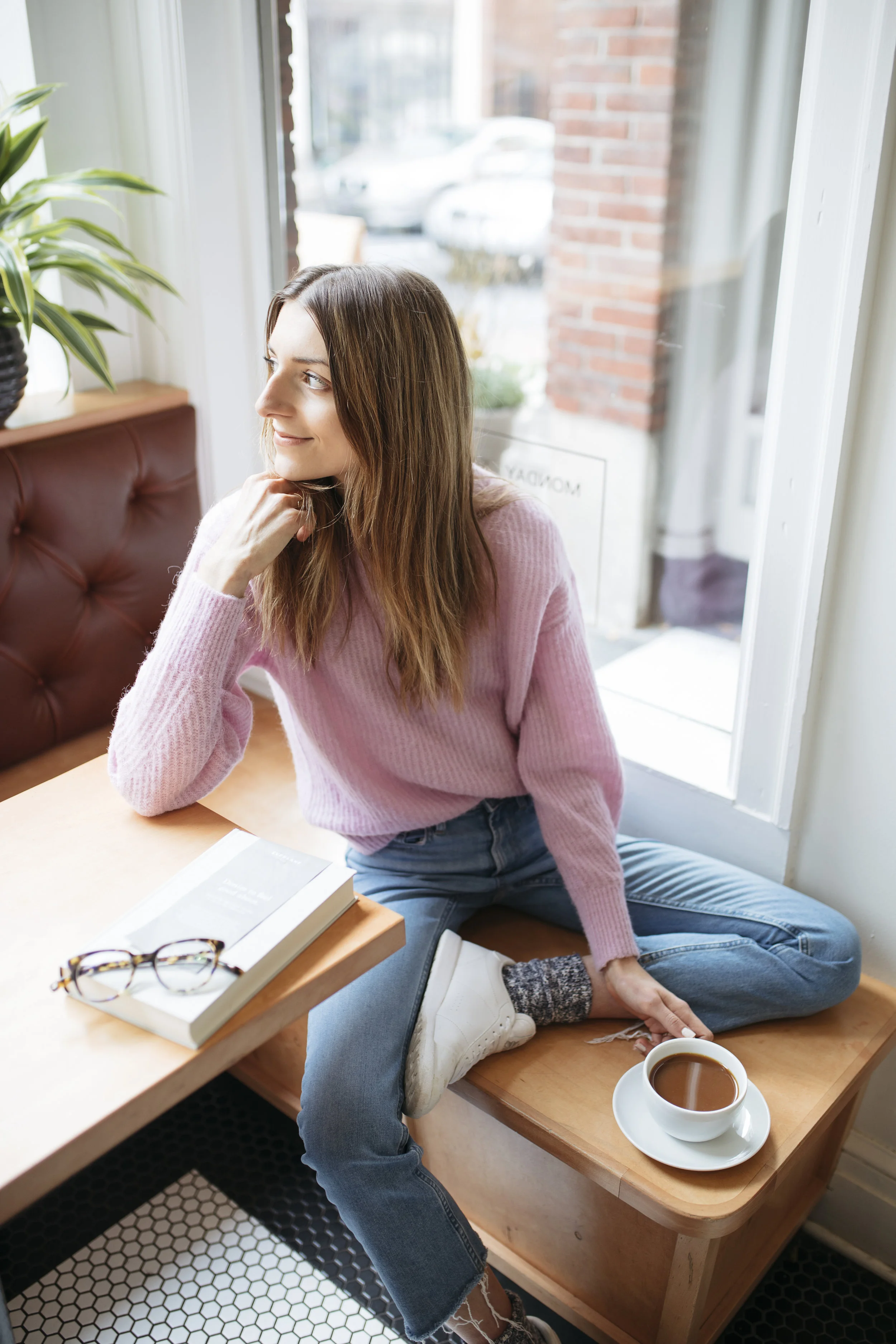Wearing an ethically made pink sweater, Emily drinks coffee and writes about how to be a better ethical shopper. Read this blog for ethical shopping tips for Black Friday