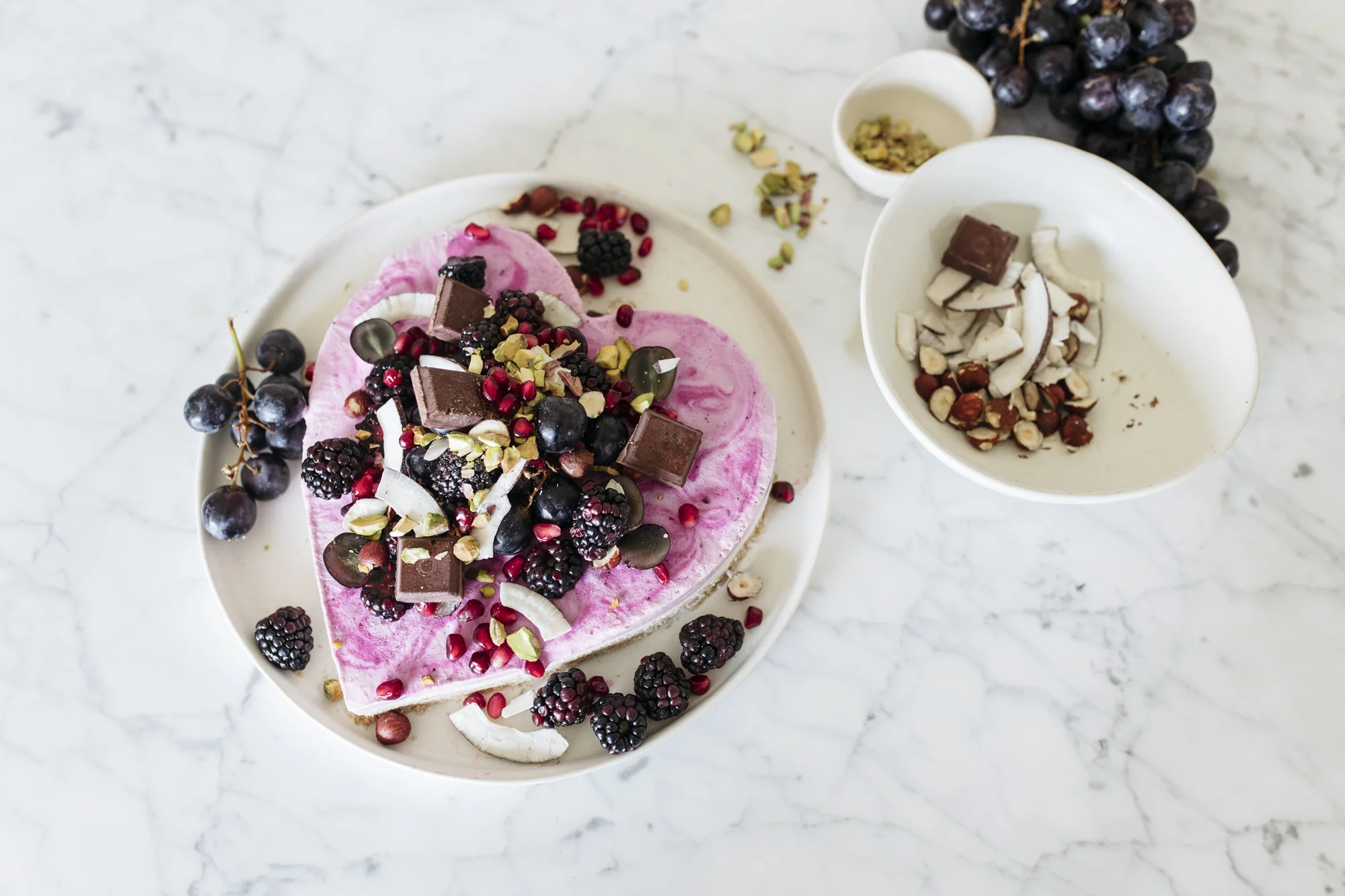 Decorate your raw valentines cake with whatever fresh fruit, nuts and chocolate you have on hand! I used black grapes, pomegranate arils, blackberries, pistachios, hazelnuts