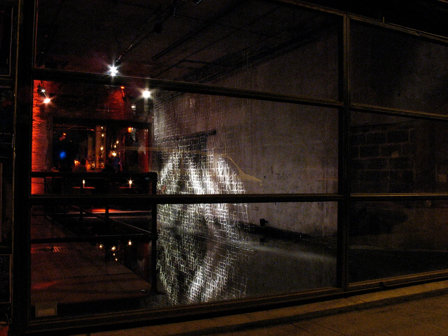 She's So Simple IIView of installation from outside Galapagos, Williamsburg, BrooklynSite-specific installation above the reflection pool at Galapagos Art Space, Williamsburg, Brooklyn, NY. Reflective embroidery thread is hand sewn into black transp…