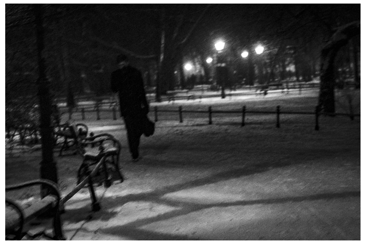 Winter Street Photography; A man in Planty during snowstorm in Kraków. 