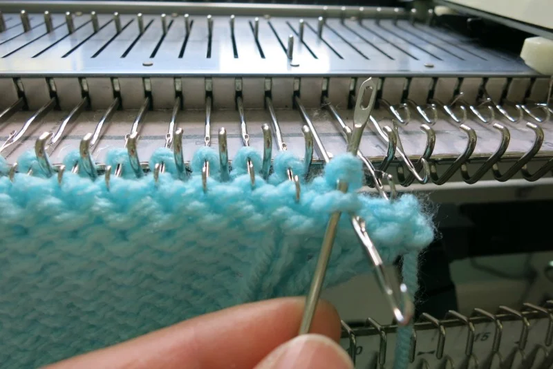 Take the yarn off the first needle, and repeat on the second stitch. Continue binding off.