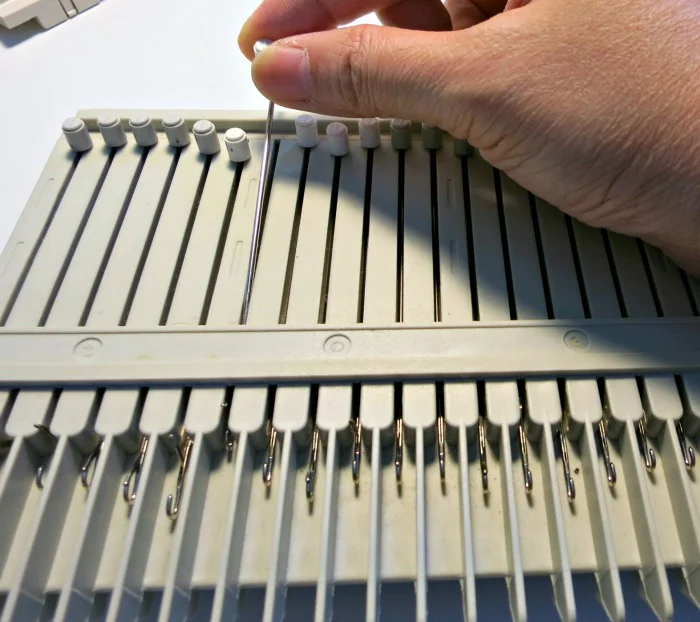 Needles are installed from the top. Make sure it goes on top (outside) of the sponge strip.