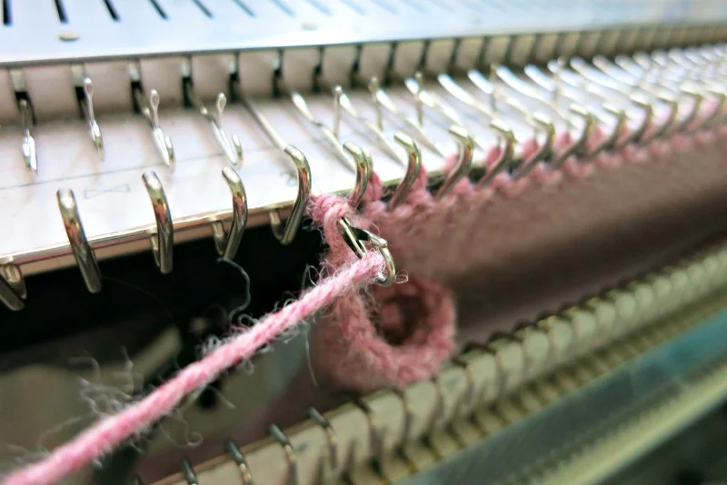 Place yarn in the open latch and push the needle all the way back to finsih the stitch. One stitch binded off. Make sure to bind off loosely.