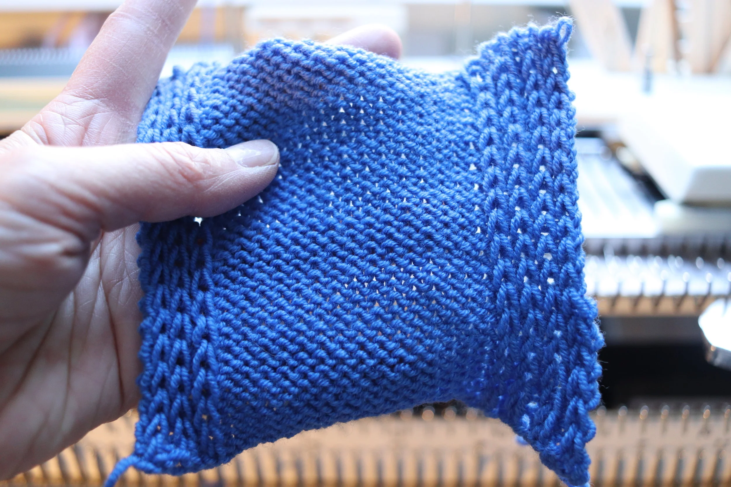 Machine knitting for a half milano stitch with no rolled edges