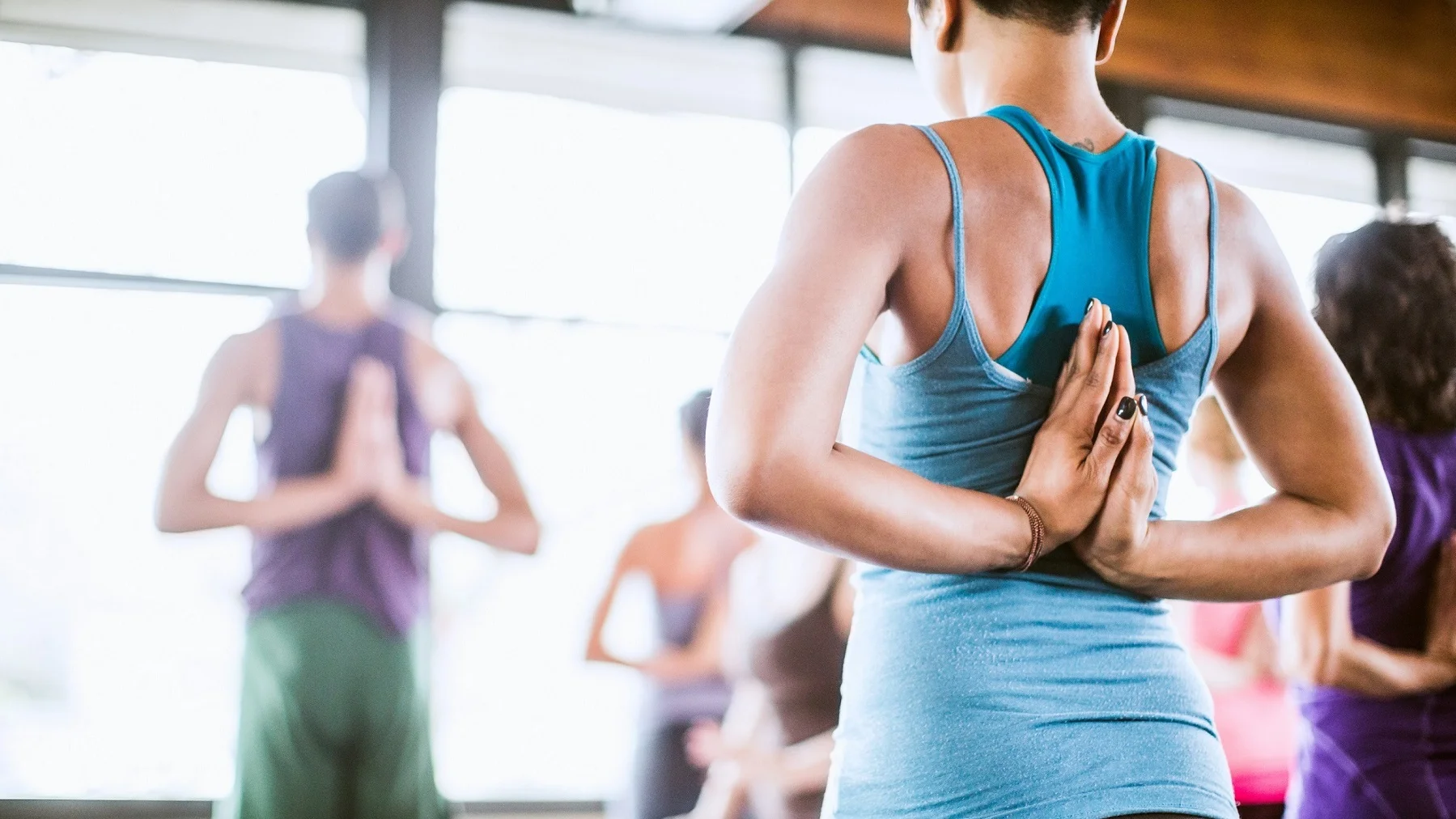 corporate yoga class doing reverse prayer hands to stretch wrists