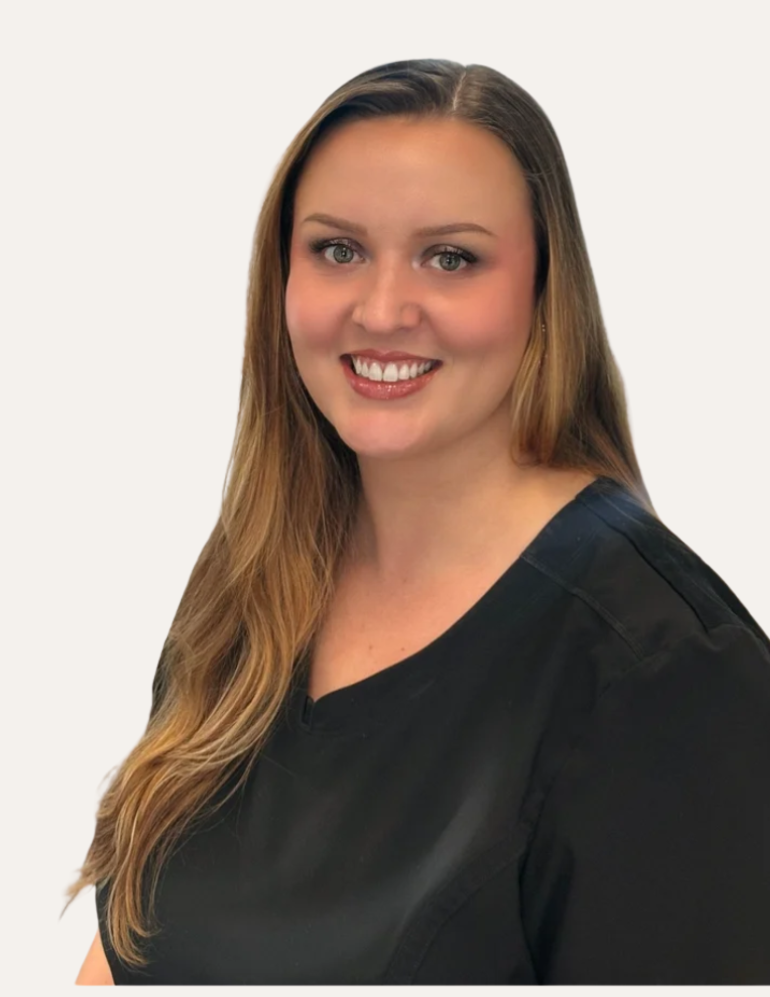 A smiling woman with long light brown hair in a black uniform, standing in a pharmacy or medical supply store.