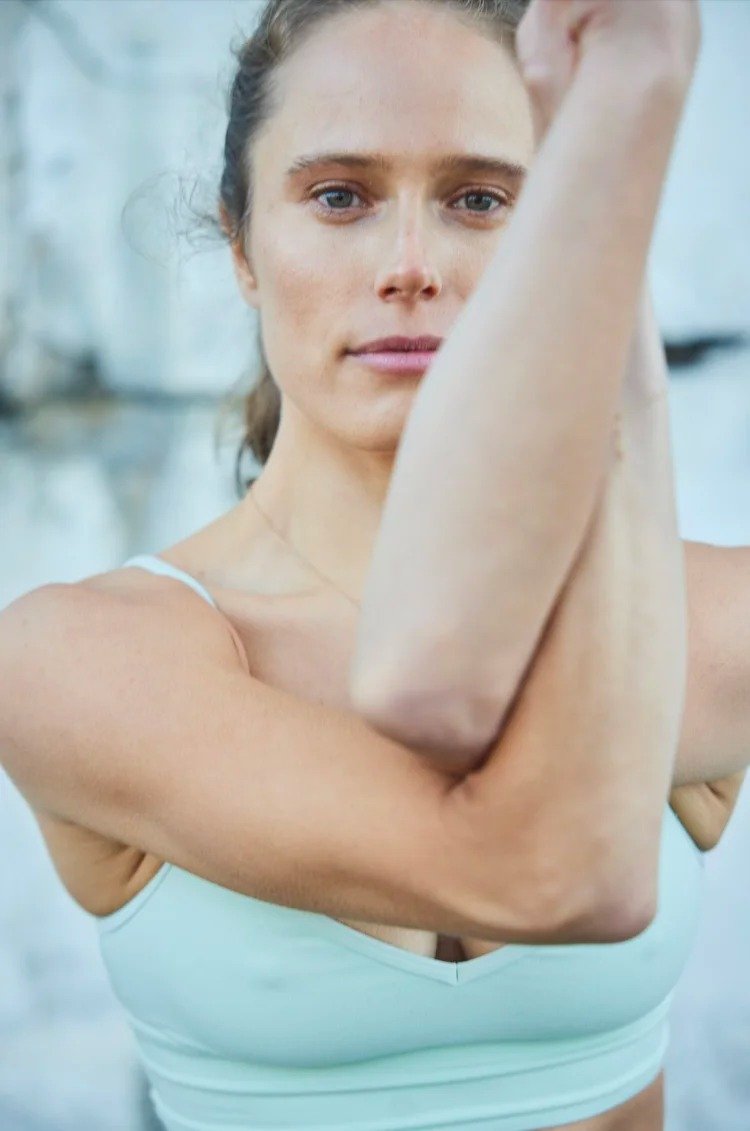 A woman stretching her arms in a fitness studio.