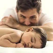 Dad watching sleeping child.jpg