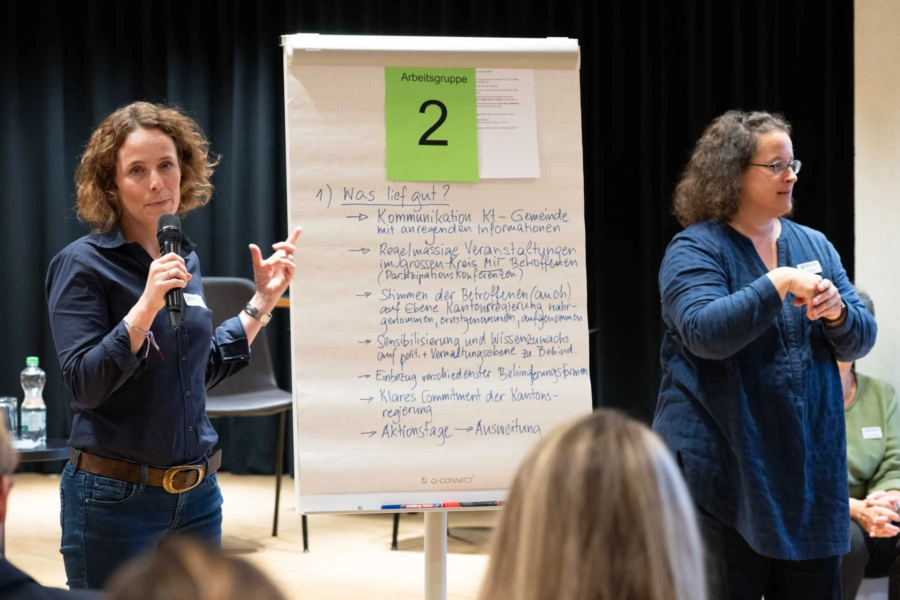 Präsentation der Gruppenresultate durch eine Frau mit Übersetzung in Gebärdensprache