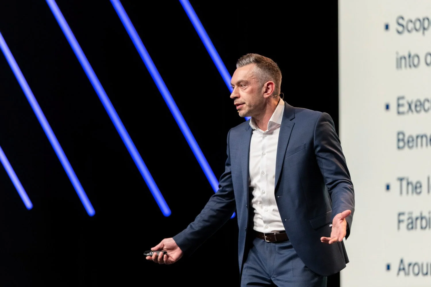 Modernes Eventfotografiebild: Speaker an Corporate Event in Zürich vor diagonalen Leuchtdioden