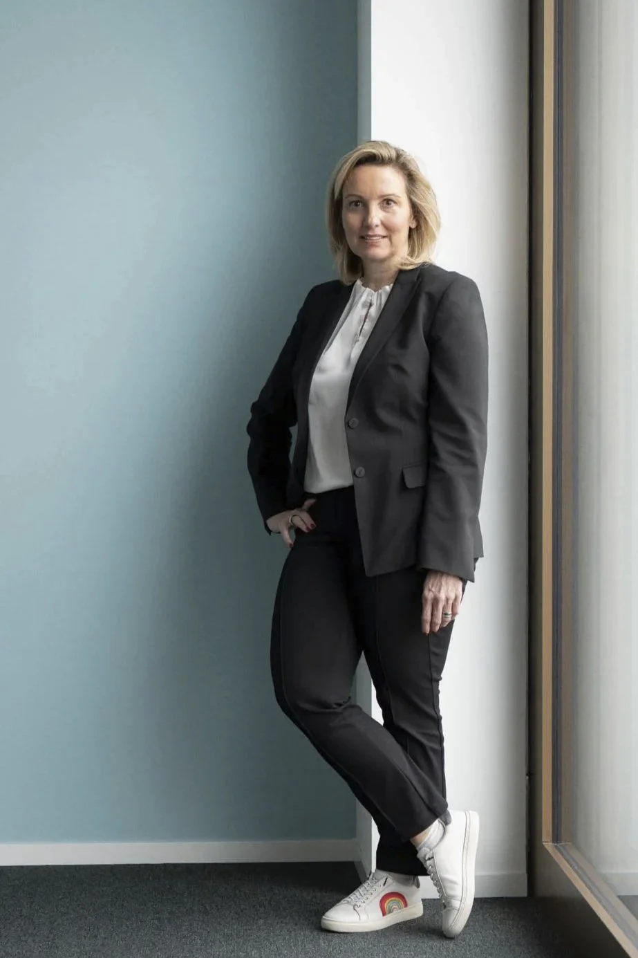 Ganzkörper-Mitarbeiter-Portrait mit available Light am Fenster im Büro des Unternehmens in Zürich