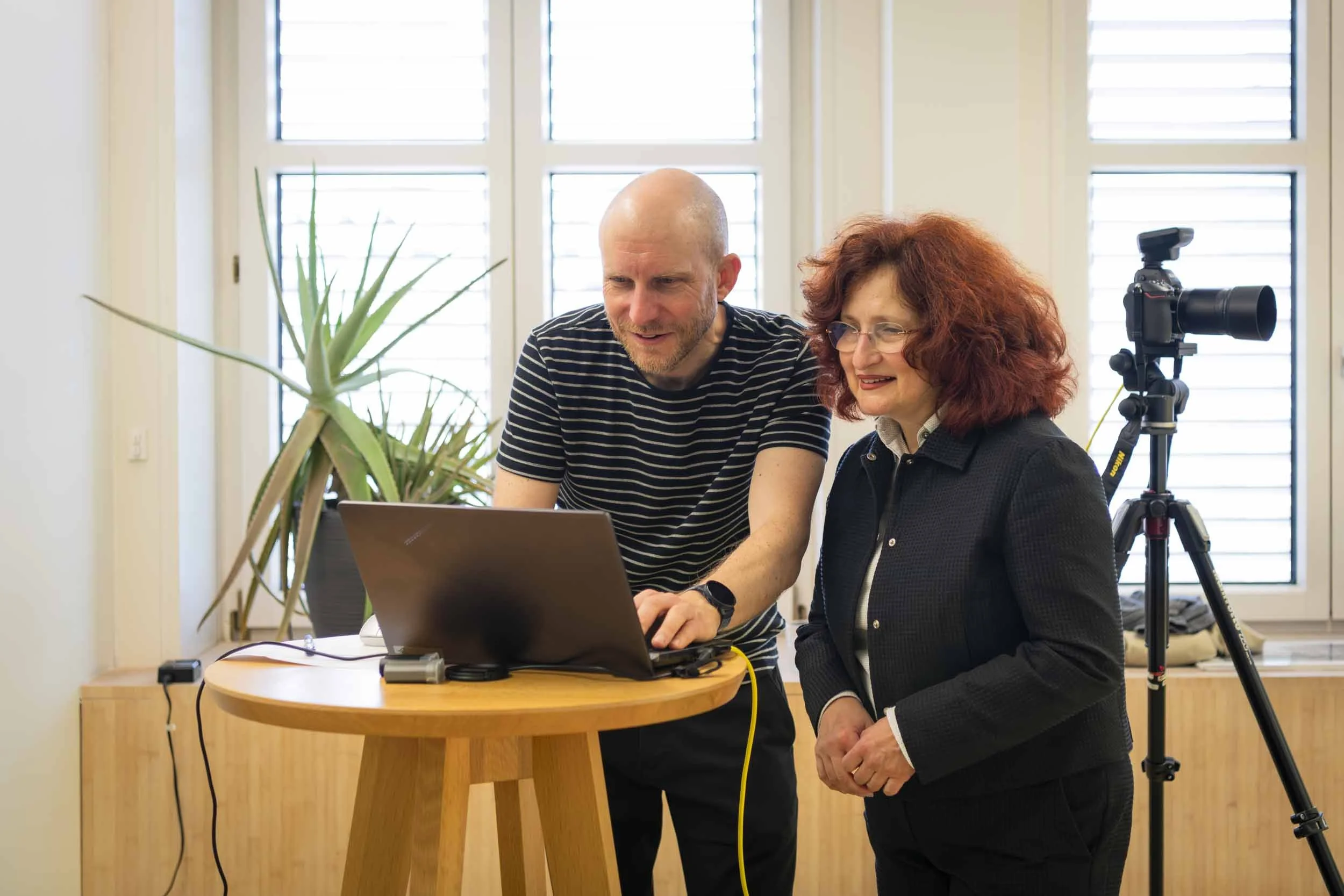 Portrait-Foto-Sichtung des Fotografen mit einer Mitarbeiterin am Laptop direkt nach dem Shooting