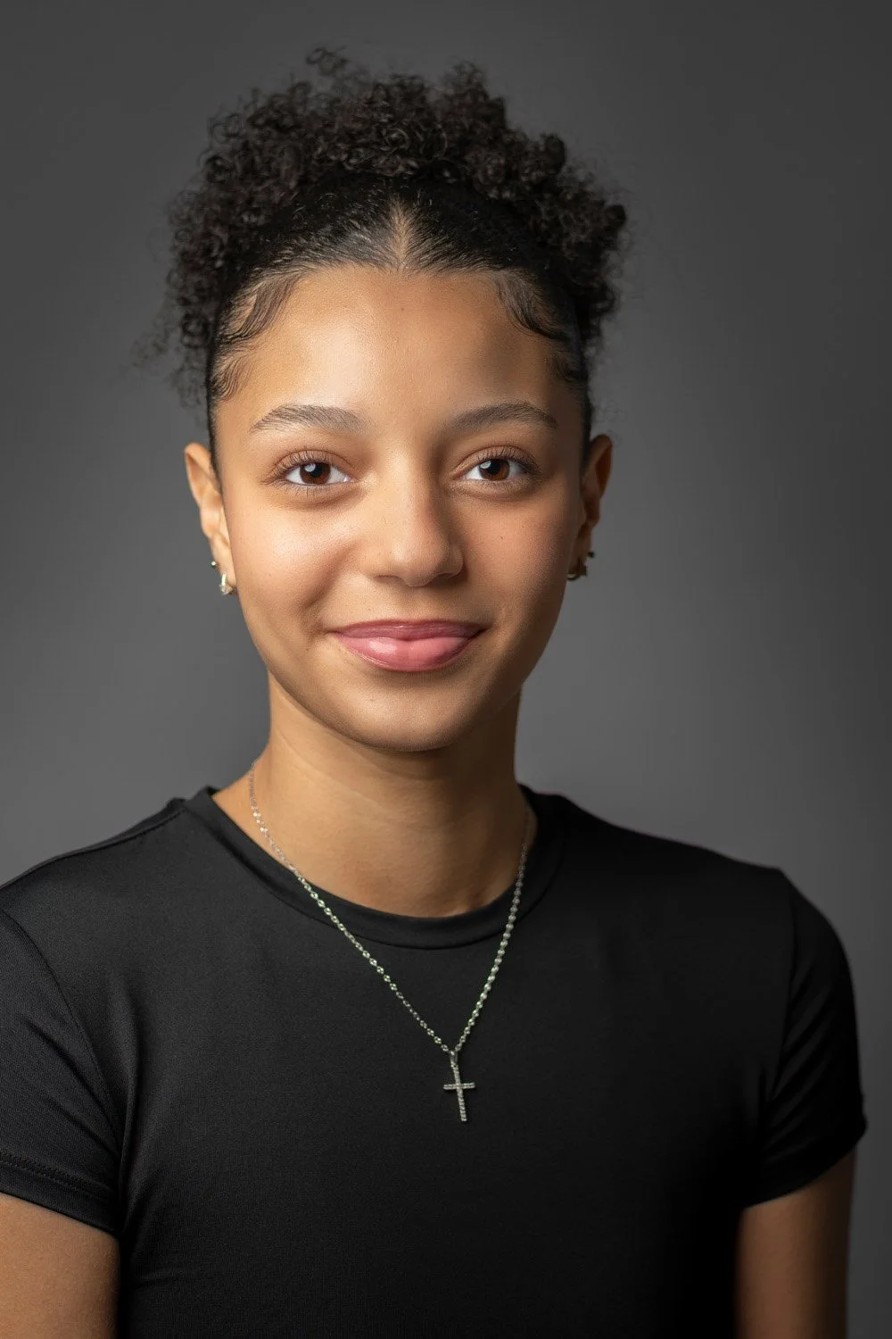 Natürliches Bewerbungsfoto einer jungen Frau vor neutralem Hintergrund