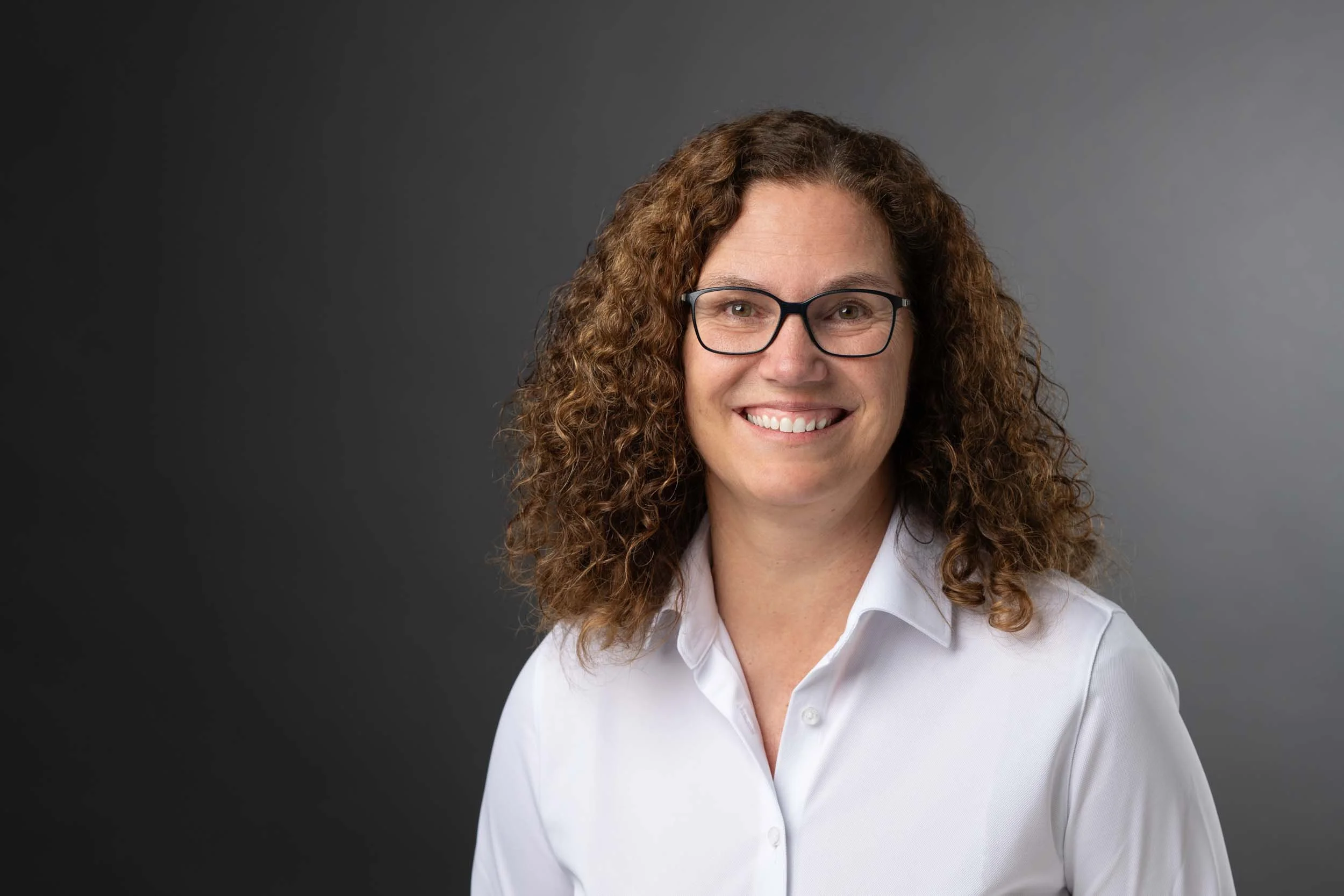 Professionelles Bewerbungsfoto einer Frau vor dunklem Studiohintergrund im Fotostudio in Zürich Oerlikon