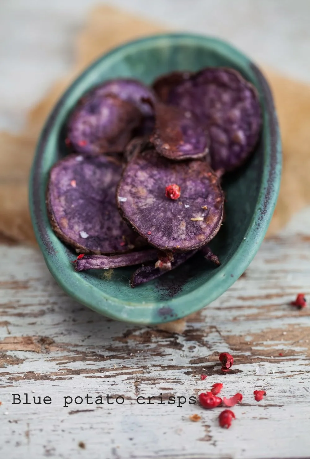 Artichoke soup with blue potato crisps and pink pepper