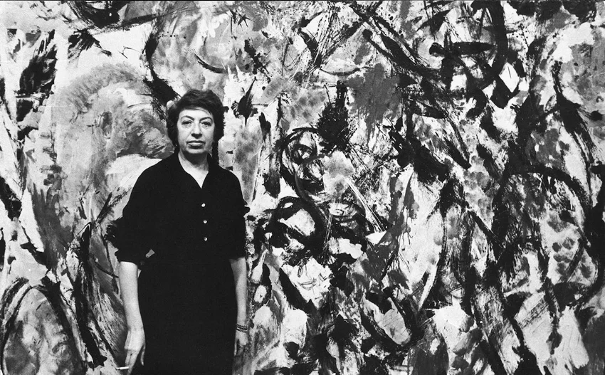 Portrait of American artist Lee Krasner in front of one of her paintings, New York, 1950s