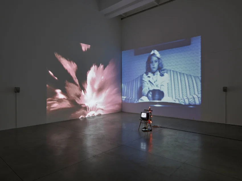 Susan Hiller, Wild Talents , 1997 Video installation: two channel video projection, with sound, one black-and-white video, monitor, chair, and votive lights. Dimensions variable. © Susan Hiller. Courtesy Lisson Gallery