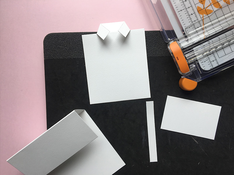 Step 5: af resterne fra kortbase 2 klippes to firkanter: En til skjorte: 1 cm x 9 cm og en til bund: 8 cm x 5 cm (se skabelon og foto). Du har nu 4 hvide dele fra dine kortbaser.