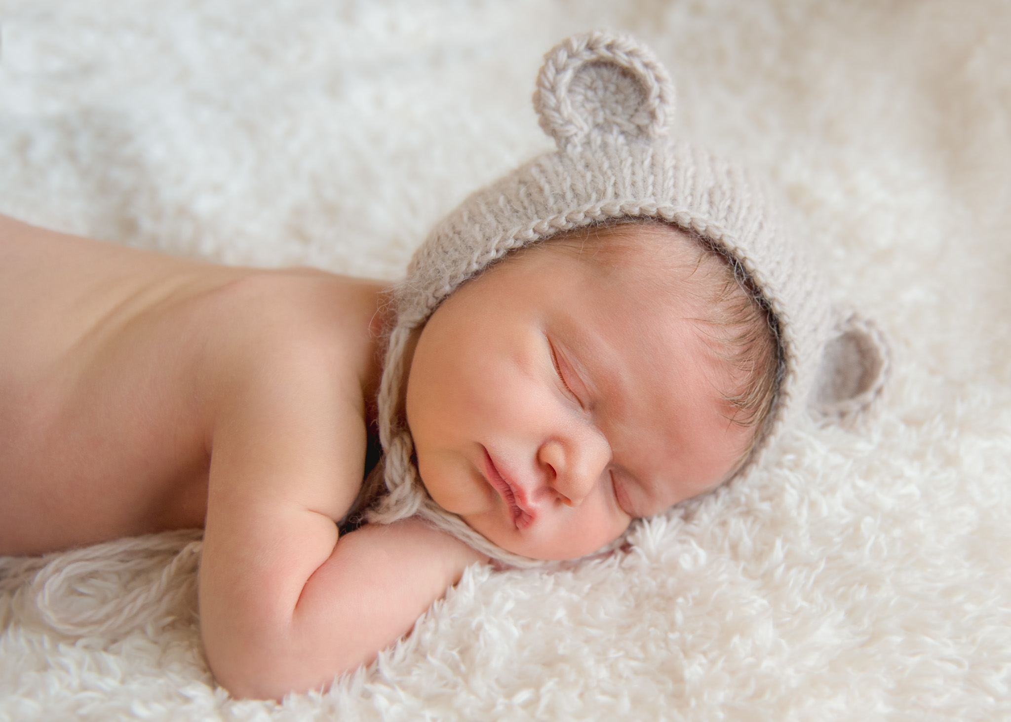  newborn sleeping in bear bonnet 