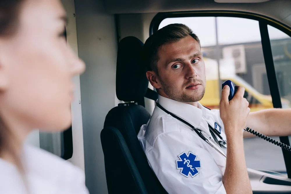 Paramedic using a vehicle-mounted two-way radio in an ambulance