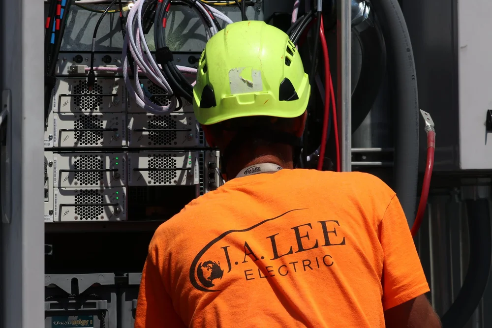 J. A. Lee Electric technician working on a telecom equipment cabinet