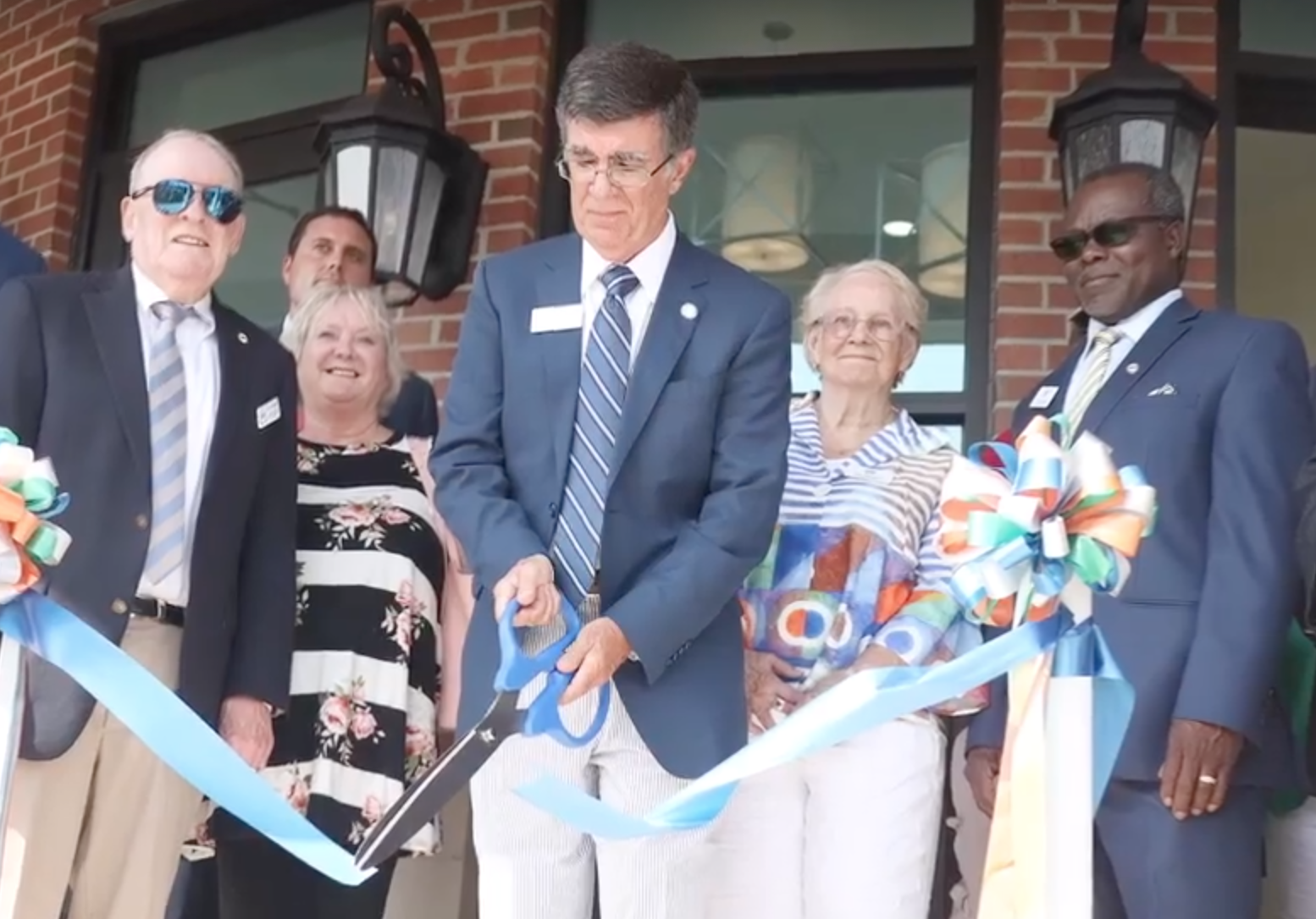 Surrounded by members of city council and other officials, Mayor Terry Mann cuts the ribbon at the new Whiteville City Hall Wednesday afternoon. (Photo by Grant Merritt)