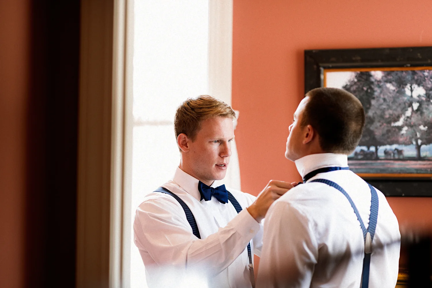 Groom helping his groomsmen get ready.