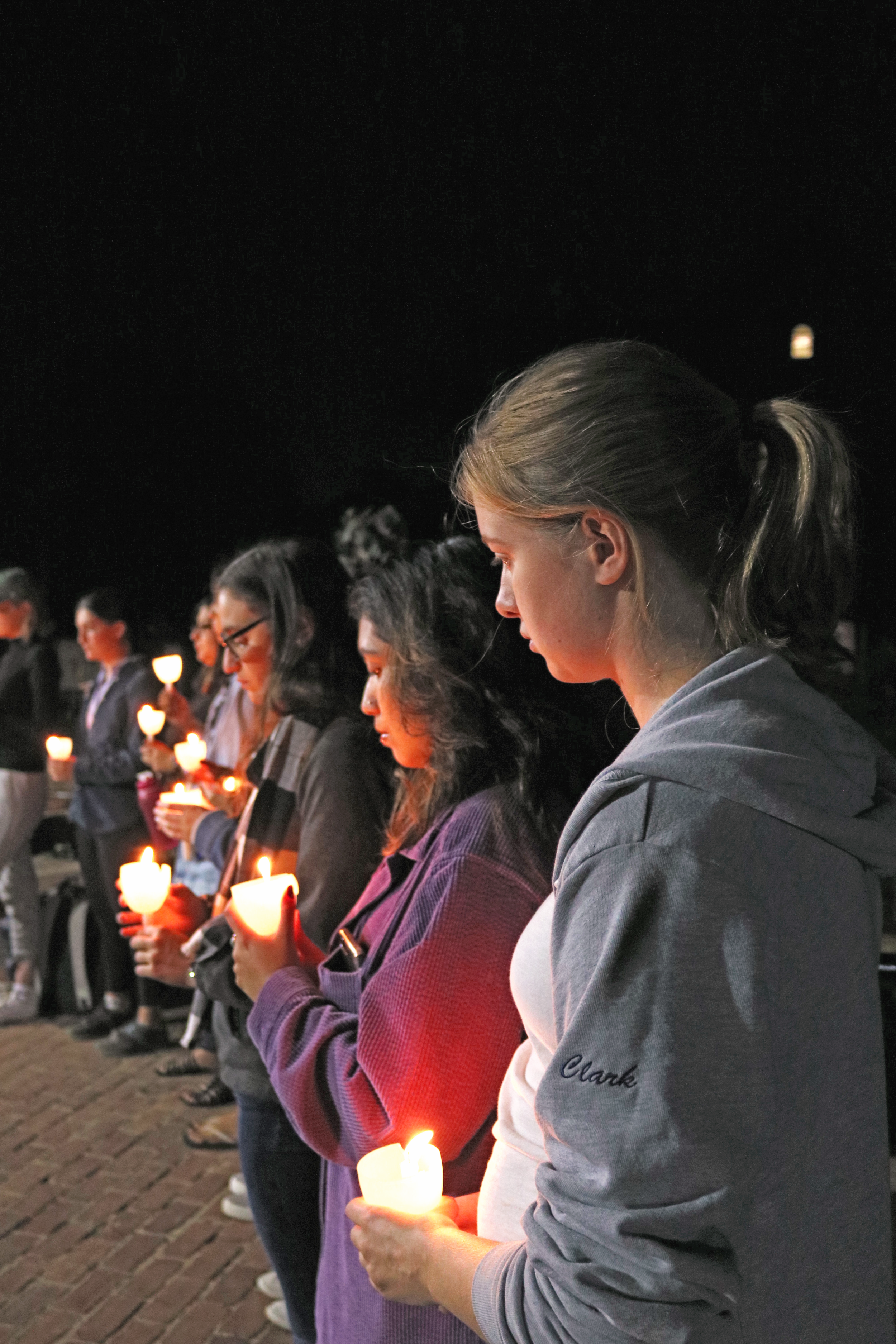 Emily Clark ’18 and other attendees held candles Friday during the vigil for victims of natural disaster in Mexico and Puerto Rico
