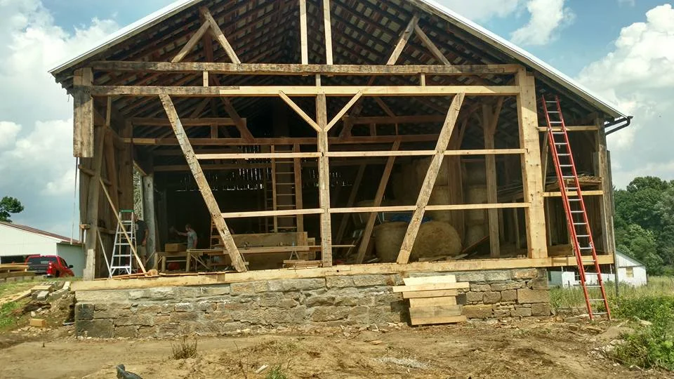 Bank barn with the west bent having rot in the sill, posts, and tie beams. Completed repair in Brewster, Oh. 