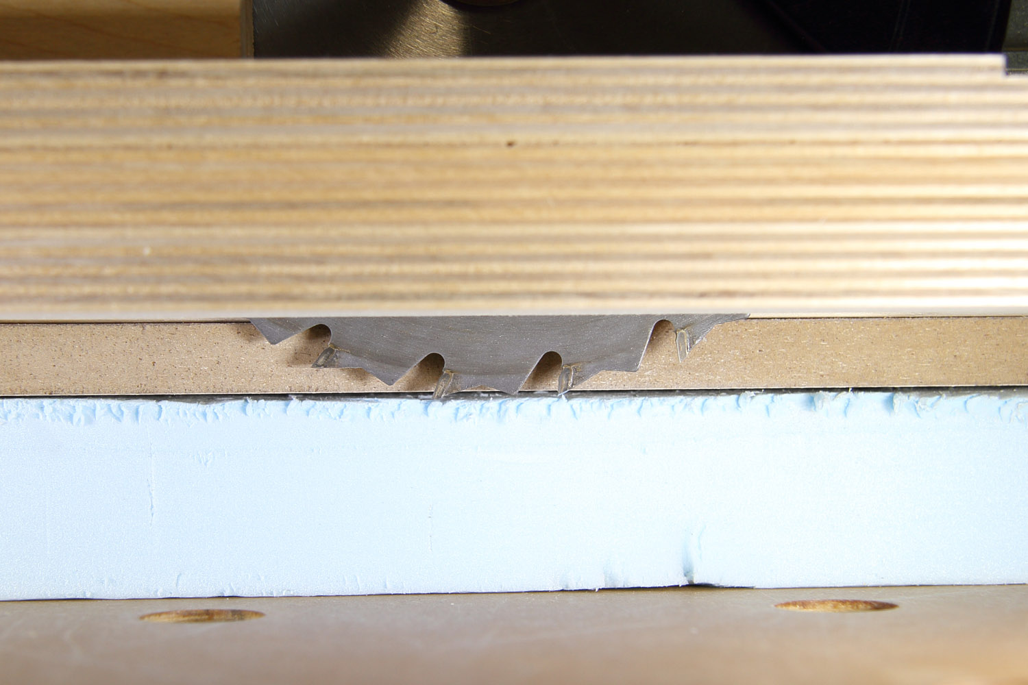 Circular saw blade just barely protrudes through flooring