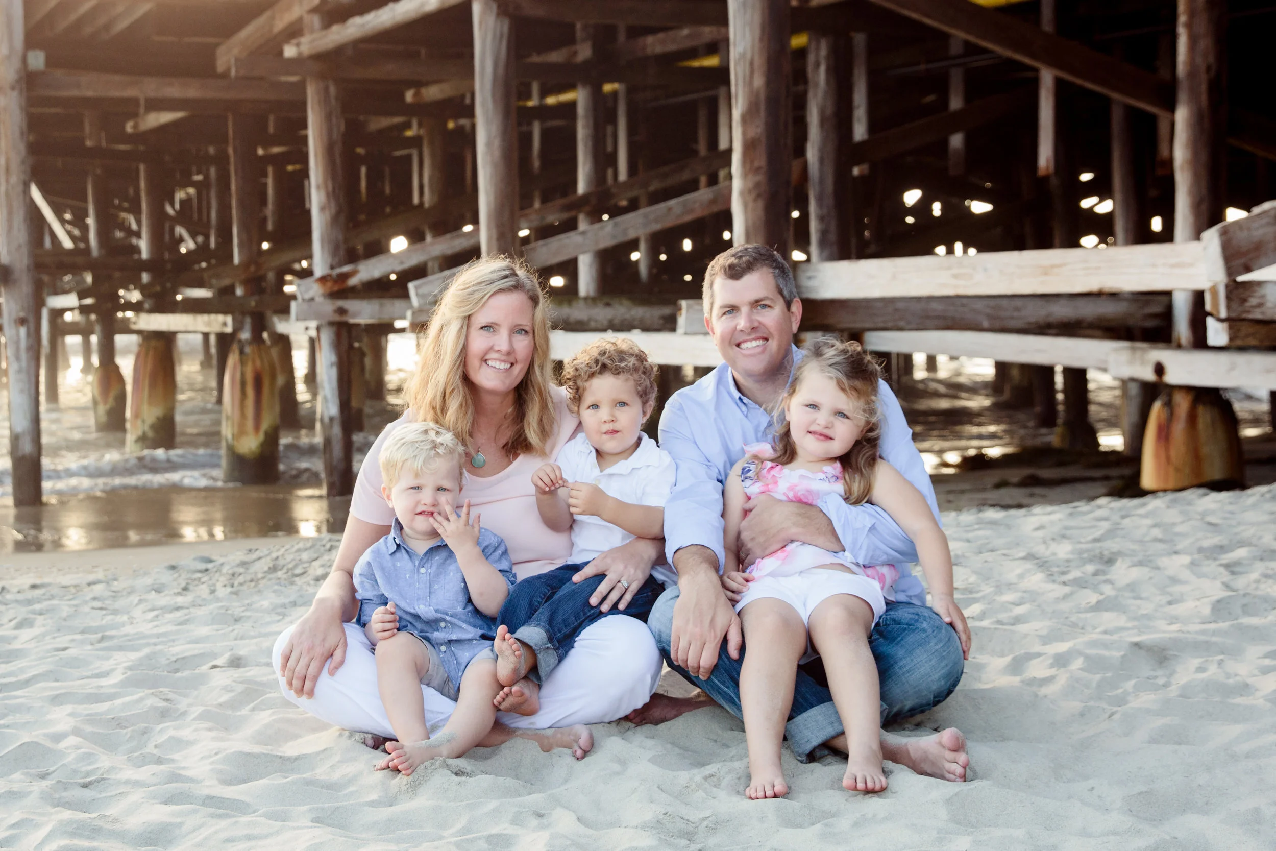 Family of five posing in San Diego for family photo.