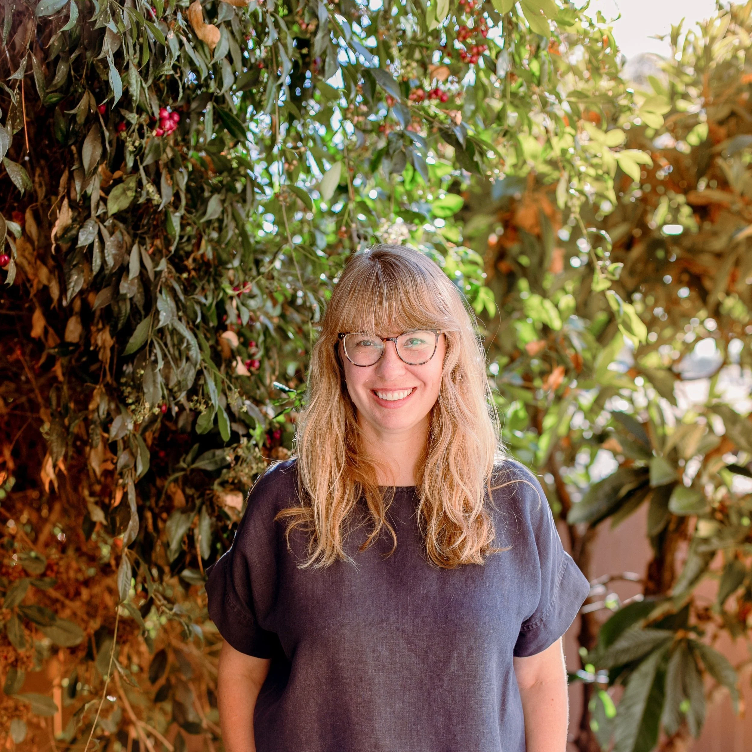 Katie Leonard, DONA certified postpartum doula at Night & Day San Diego smiling for professional headshot outside.