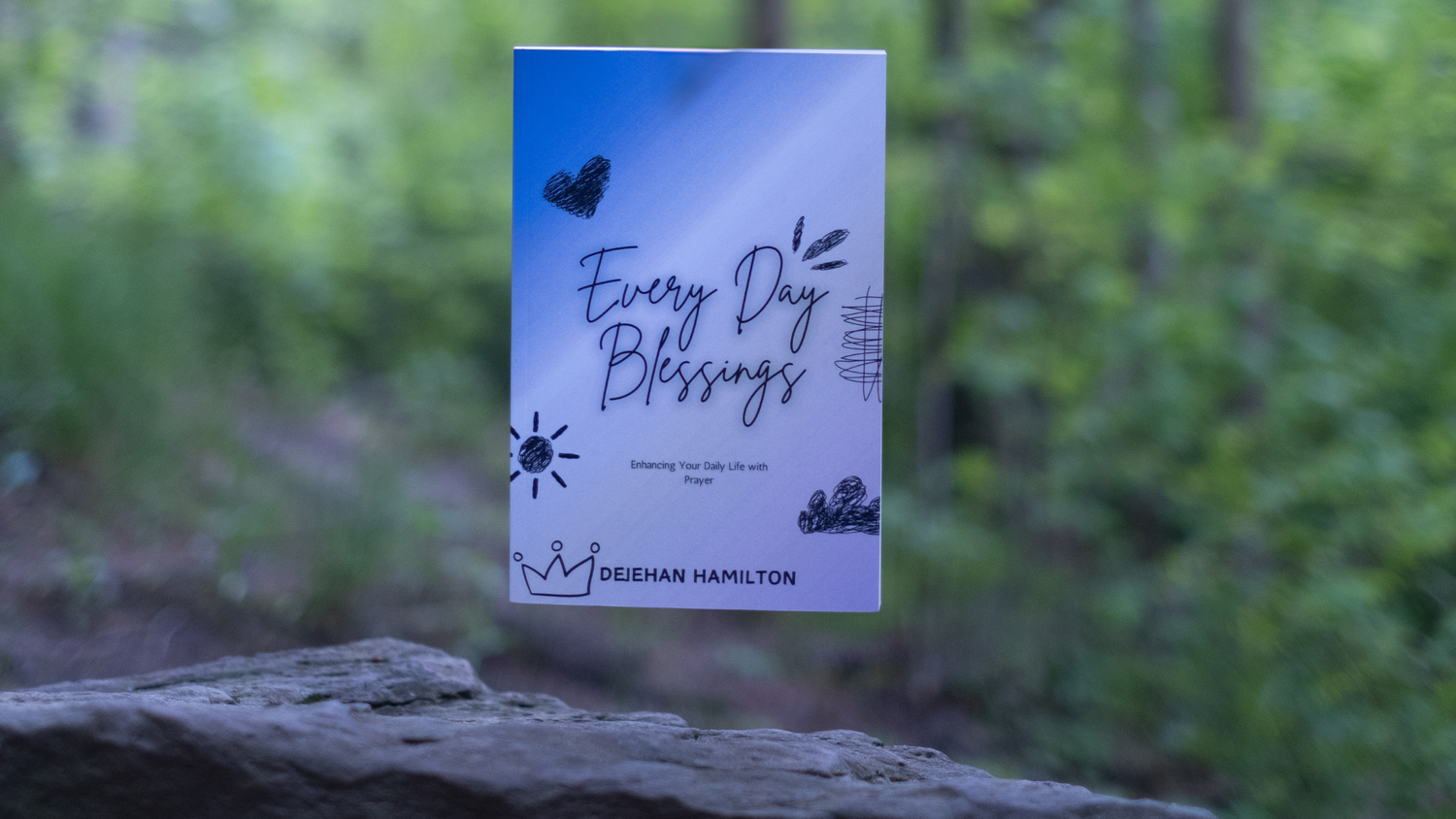 The physical Every Day Blessings prayer book by Dejehan Hamilton, photographed outdoors