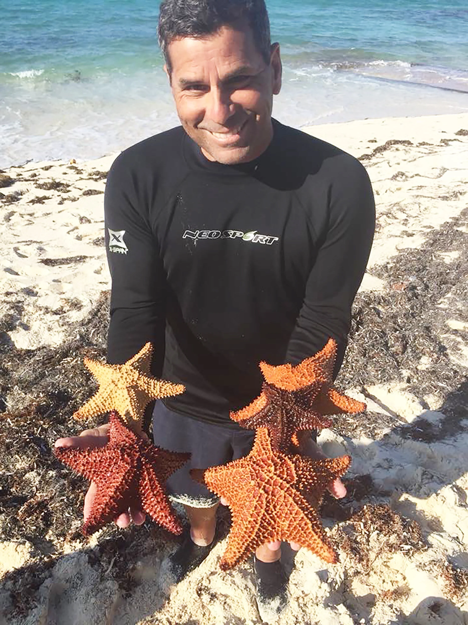 Biology professor Isidro Bosch (pictured above) displays his love for the ocean, holding a series of starfish in his hands. Bosch also has a passion for Antarctica, where he has conducted research and taken students on study abroad trips (courtesy of Isidro Bosch).