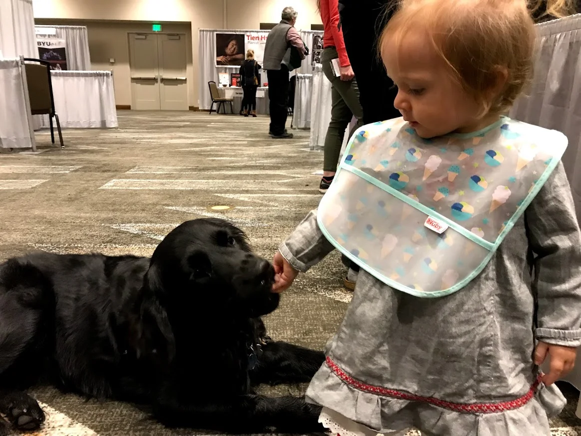 Juno making friends IN the exhibit hall at the conference. Anyone who has treats and is close to the ground is a perfect friend in her book!!!