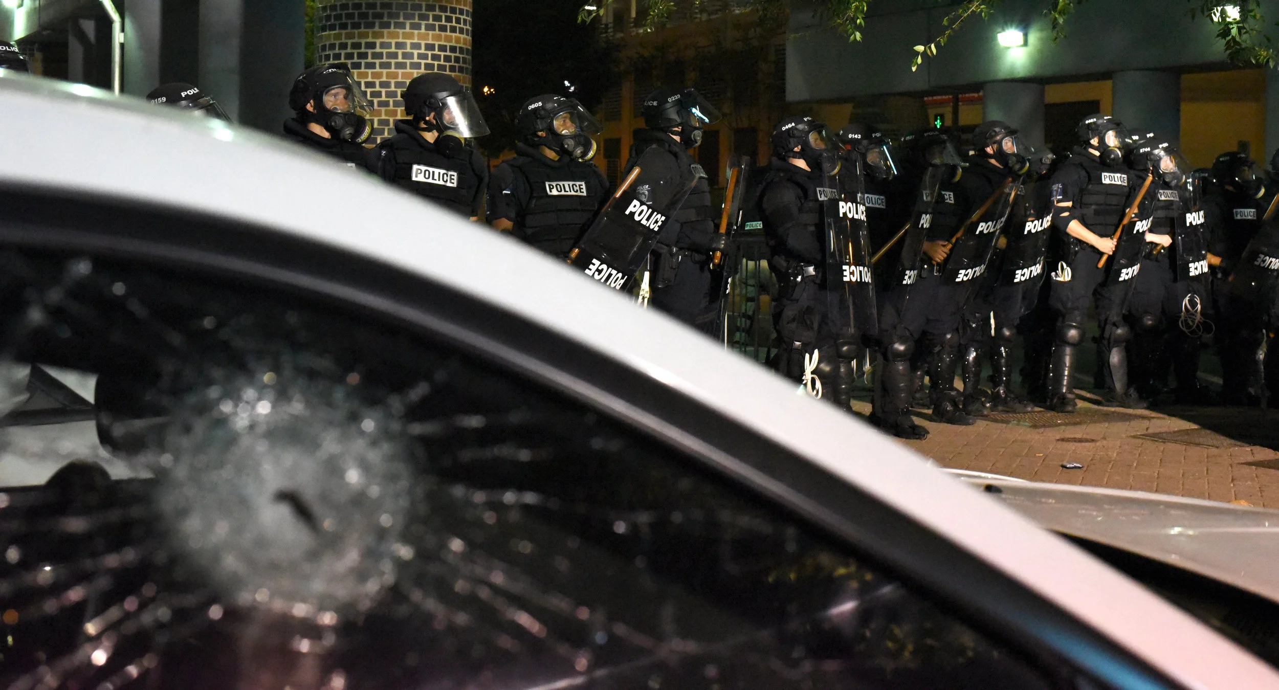  &nbsp;Riot police officers stand near an automobile with a smashed window as they confront protestors in Charlotte, North Carolina, USA, 21 September 2016. North Carolina governor Pat McCrory declared a state of emergency after protesters took to th